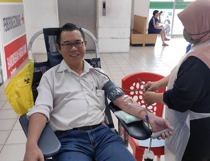 图：陈泓宾（左）在捐血活动中献血，为麻坡医院血库补充血浆。